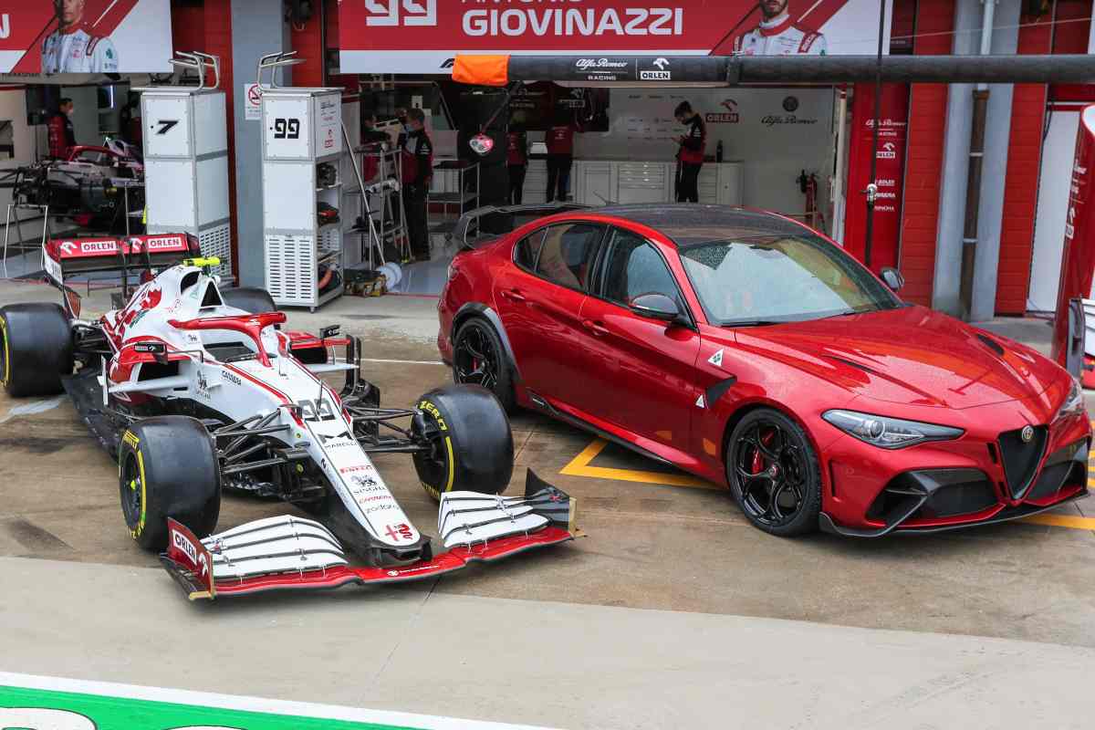 La Alfa Romeo Giulia GTAm con la C41 di Formula 1 nella corsia dei box del circuito di Imola alla vigilia del Gran Premio dell'Emilia Romagna