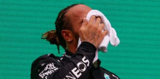 Lewis Hamilton si deterge il sudore sul podio del Gran Premio d'Ungheria di F1 2021 a Budapest