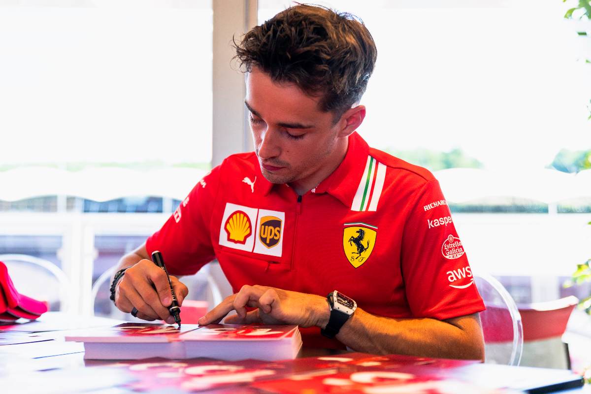 Charles Leclerc firma un autografo a un tifoso