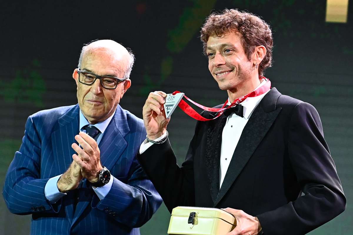 Carmelo Ezpeleta consegna a Valentino Rossi la medaglia alle premiazioni della MotoGP 2021