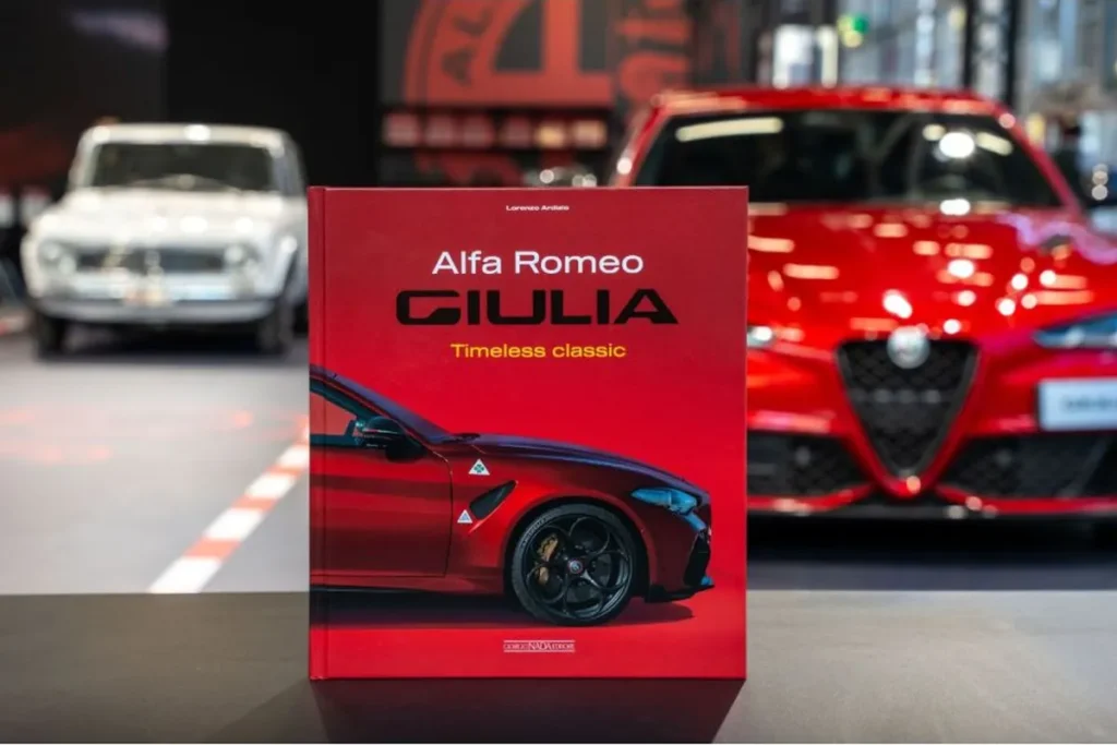Alfa Romeo Giulia, il libro Timeless Classic davanti alle vetture nello stand di Bologna